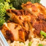 Sliced chipotle chicken breast next to broccoli and brown rice inside of a glass meal prep container.