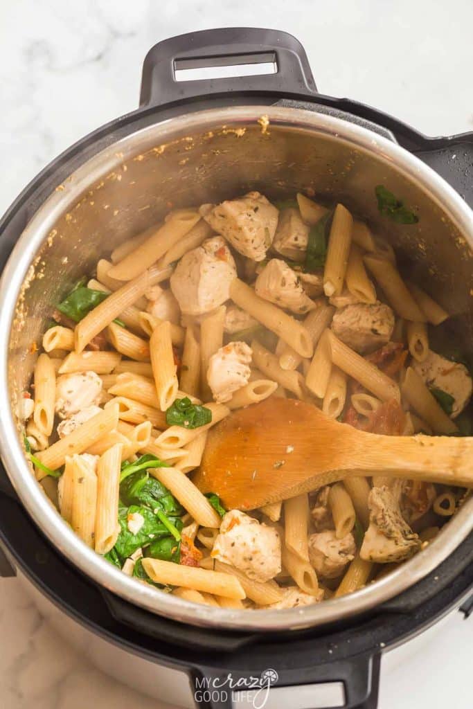 top down view of Instant Pot with pasta, chicken, and seasonings for Tuscan Chicken Pasta