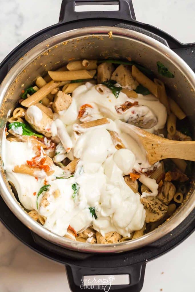 top down view of Instant pot. Adding cheese mixture to the recipe. 