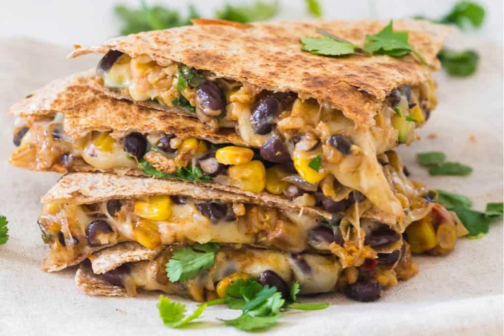 close up of pieces of veggie quesadillas, stacked on top of one another