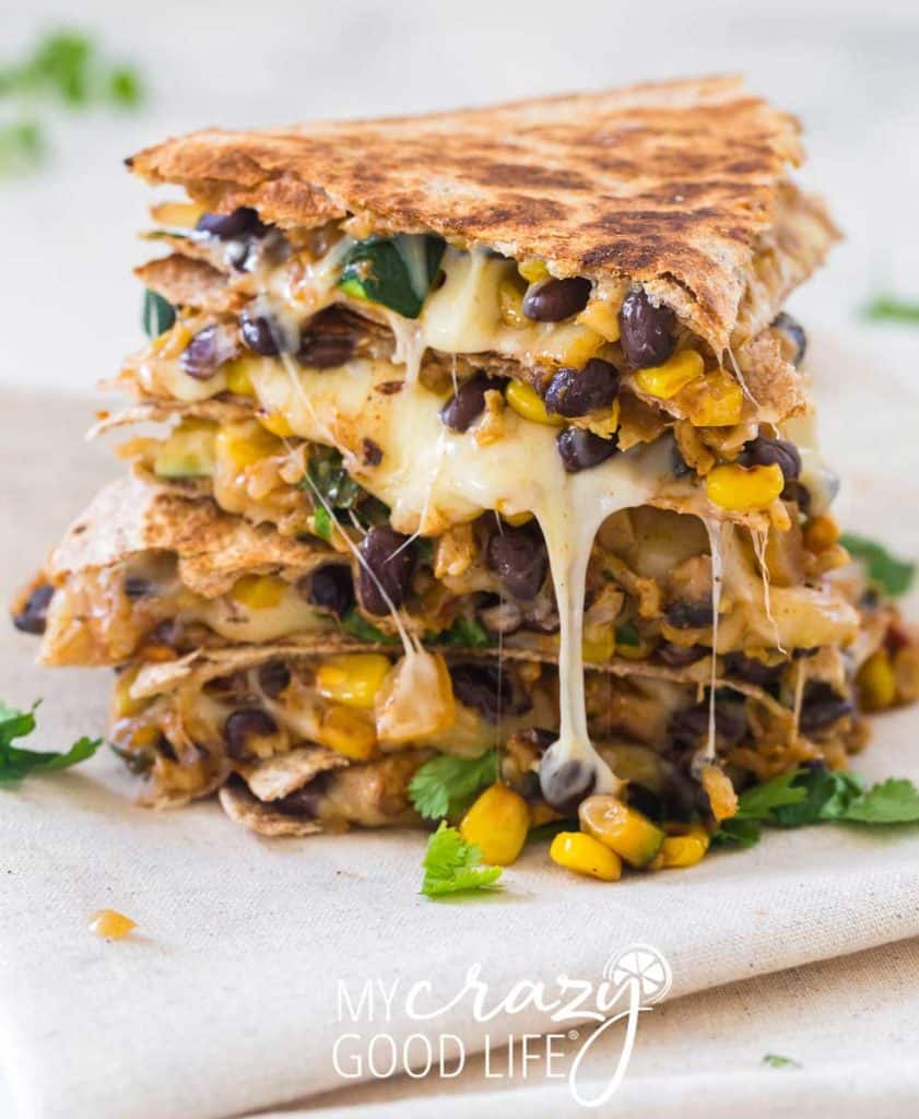 stacked pieces of veggie quesadilla with cheese dripping