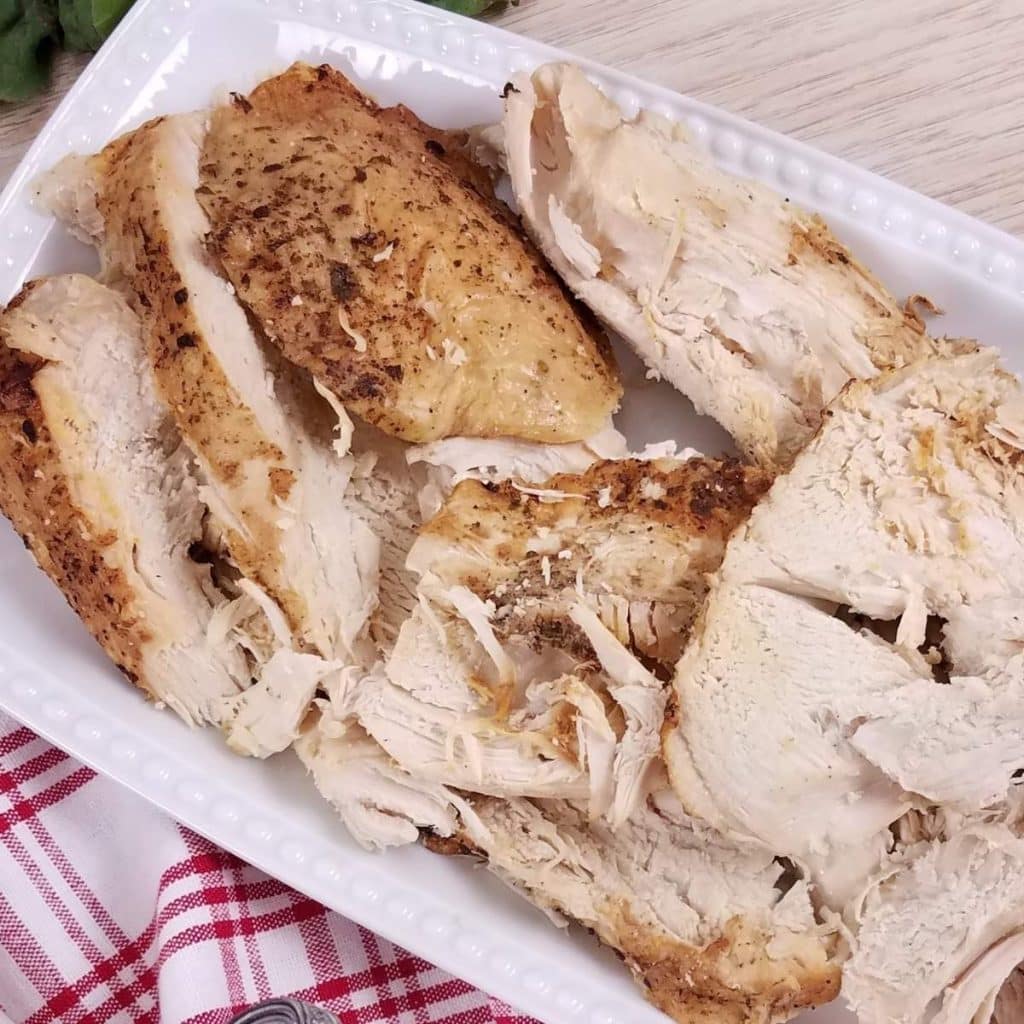 A white rectangular platter with sliced turkey breast.