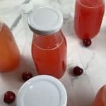 Glass bottles filled with homemade energy drink and capped with a white lid.