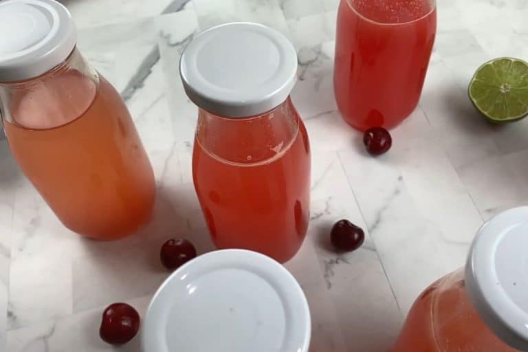 Glass bottles filled with homemade energy drink and capped with a white lid.