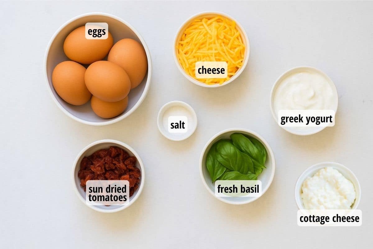 white countertop with seven bowls full of ingredients needed to make egg bites.