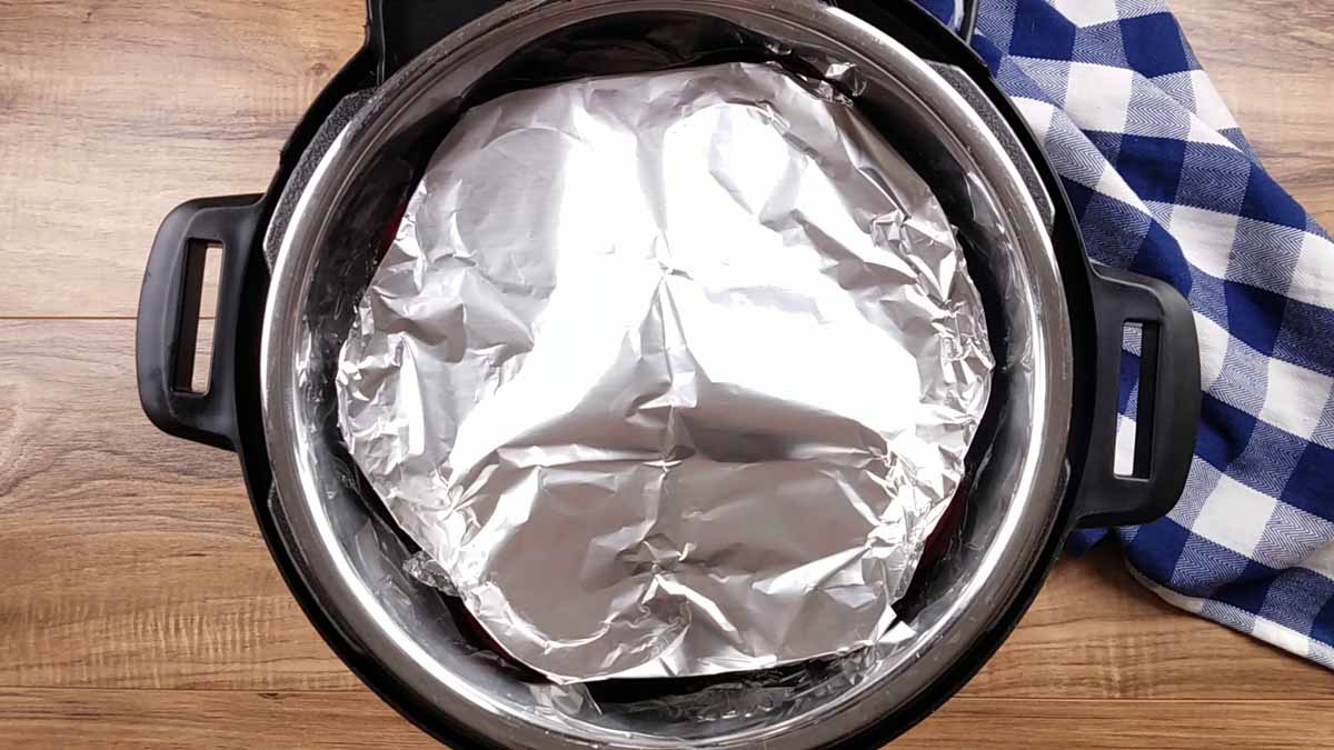image of an instant pot with foil covering a silicone egg bite mold.