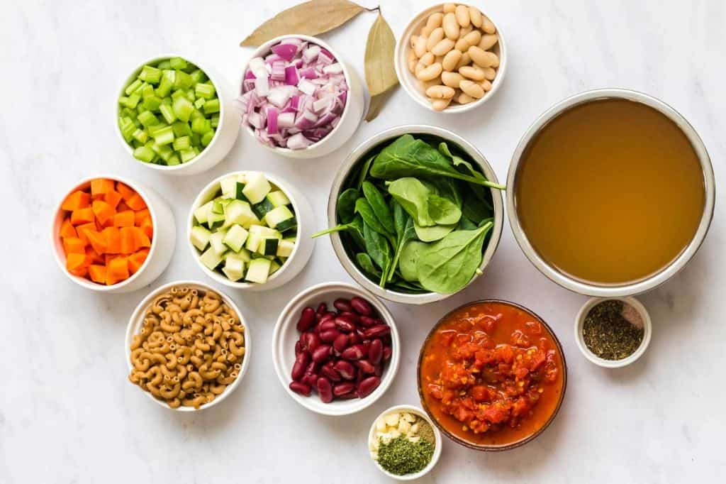 ingredients needed for this vegan minestrone soup in small white bowls