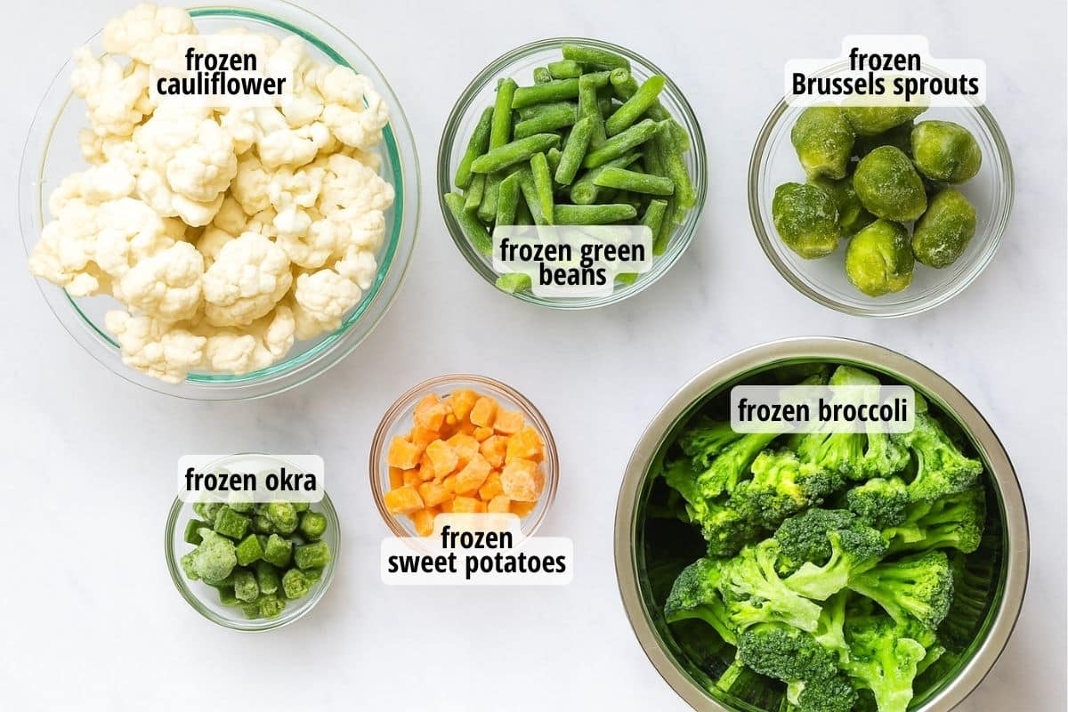 marble countertop with bowls full of labeled frozen vegetables.
