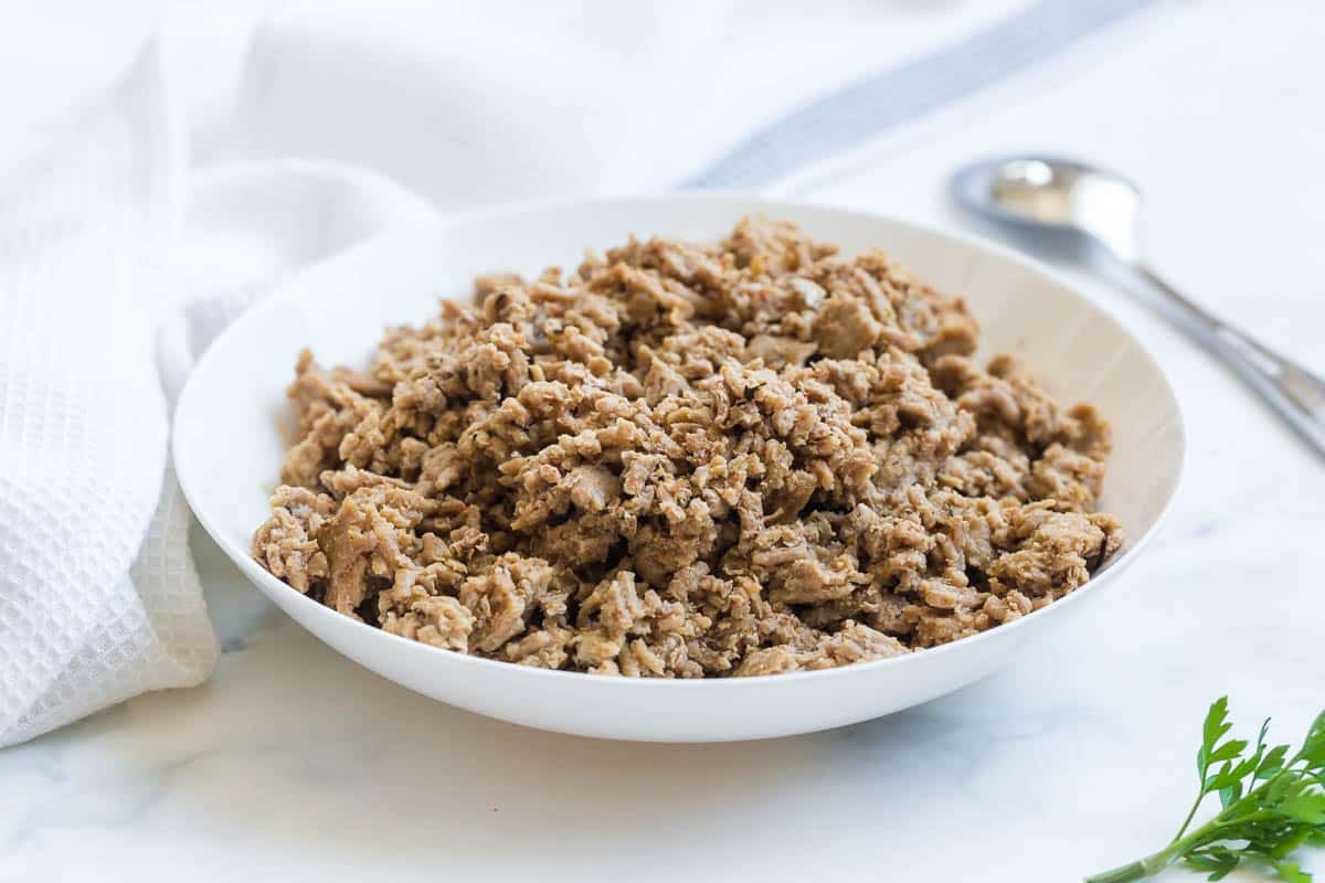 White bowl full of cooked ground turkey crumbles.