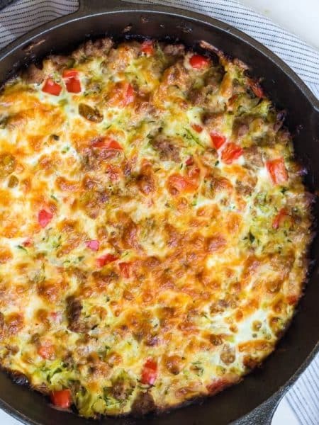 A large cast iron skillet with a baked zucchini breakfast casserole inside of it.