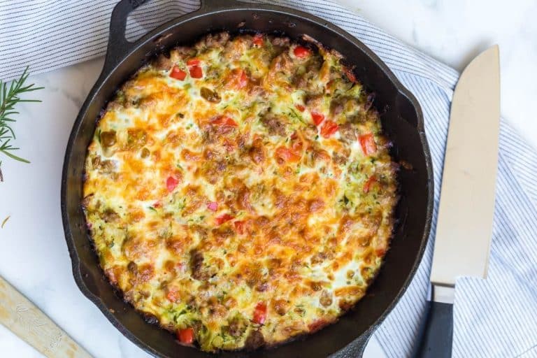A large cast iron skillet with a baked zucchini breakfast casserole inside of it.