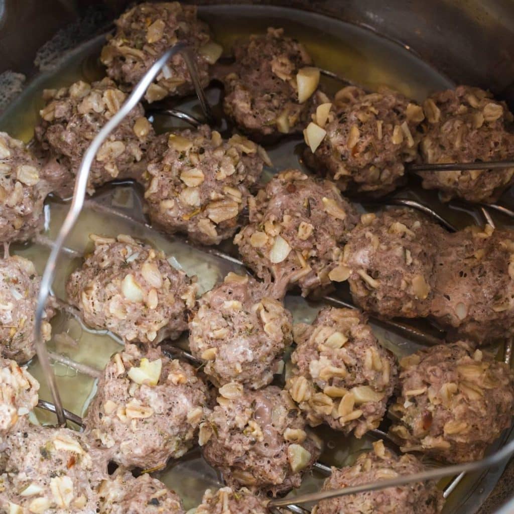 Meatballs inside an instant pot after they are done being cooked.