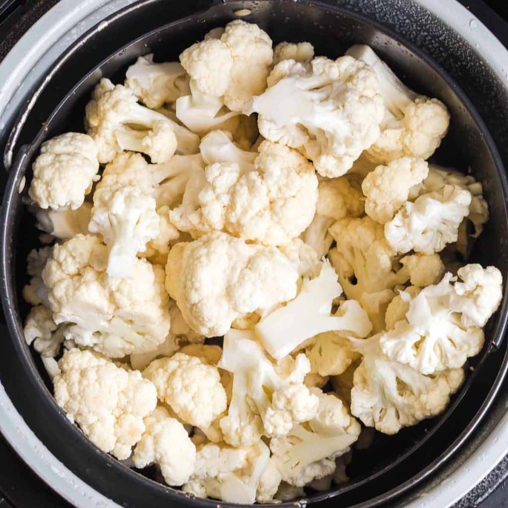 cauliflower florets inside an air fryer.