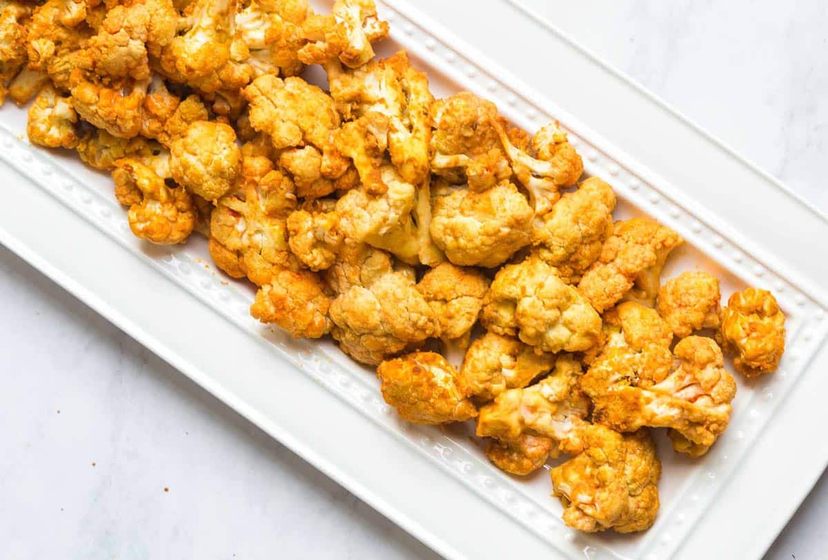 Air fried buffalo cauliflower on a white rectangular plate.