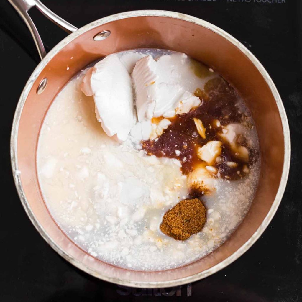 Copper pot on the stove that contains all of the ingredients for this homemade coffee creamer recipe.