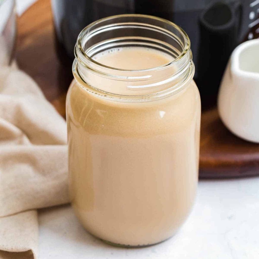 Mason jar with no lid filled with homemade vanilla coffee creamer.