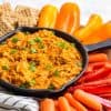 buffalo chicken dip in a skillet surrounded by dipping vegetables and crackers