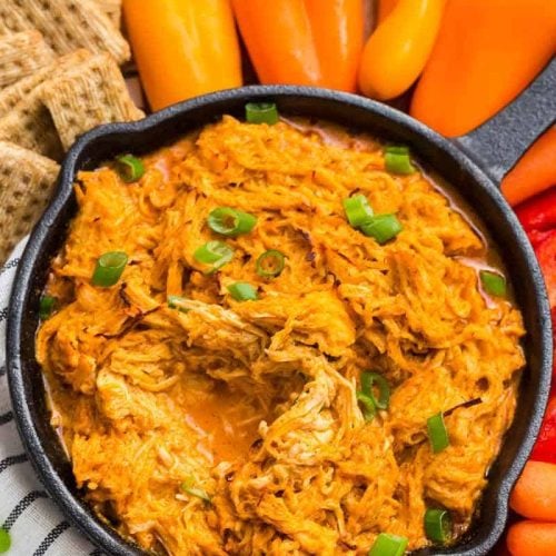 Weight Watchers Buffalo Chicken Dip in a skillet surrounded by vegetables and crackers.