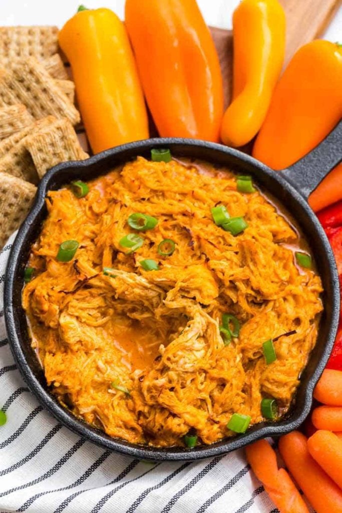 Weight Watchers Buffalo Chicken Dip in a skillet surrounded by vegetables and crackers.