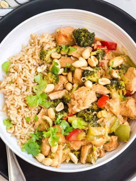 Healthy Kung Pao Chicken in a white bowl on top of a black plate
