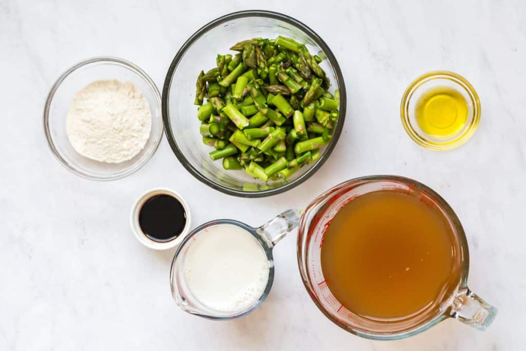 ingredients used to make asparagus soup including: asparagus, vegetable broth, almond milk, balsamic vinegar, flour, and oil