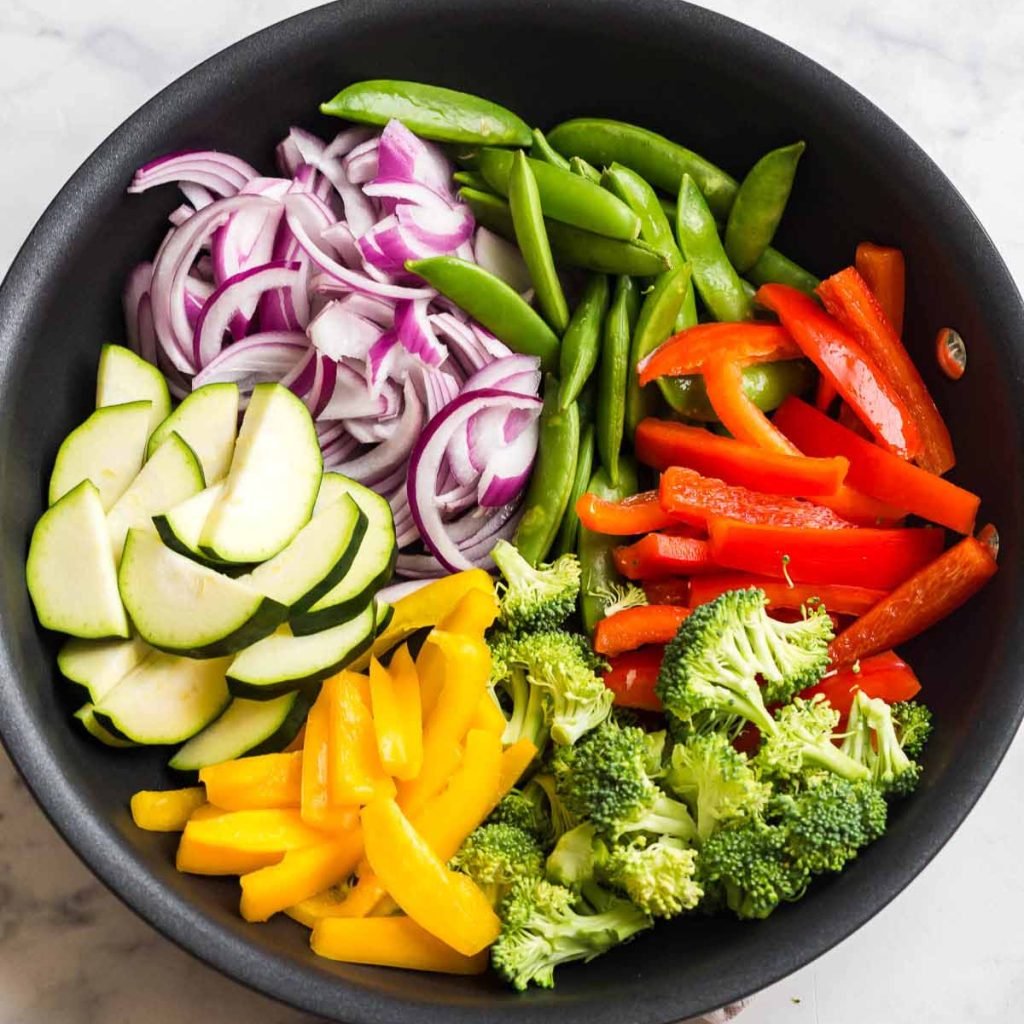 matte black pan of cut and prepped veggies for stir fry bowls
