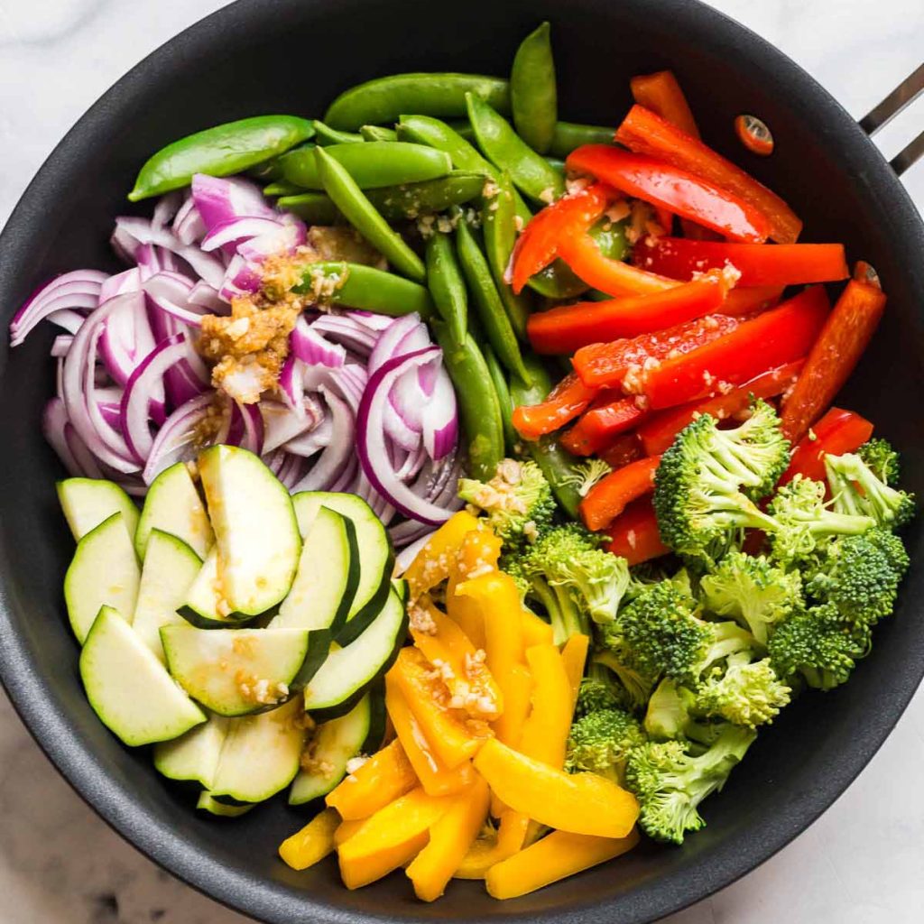 pan of stir fry veggies with seasonings added