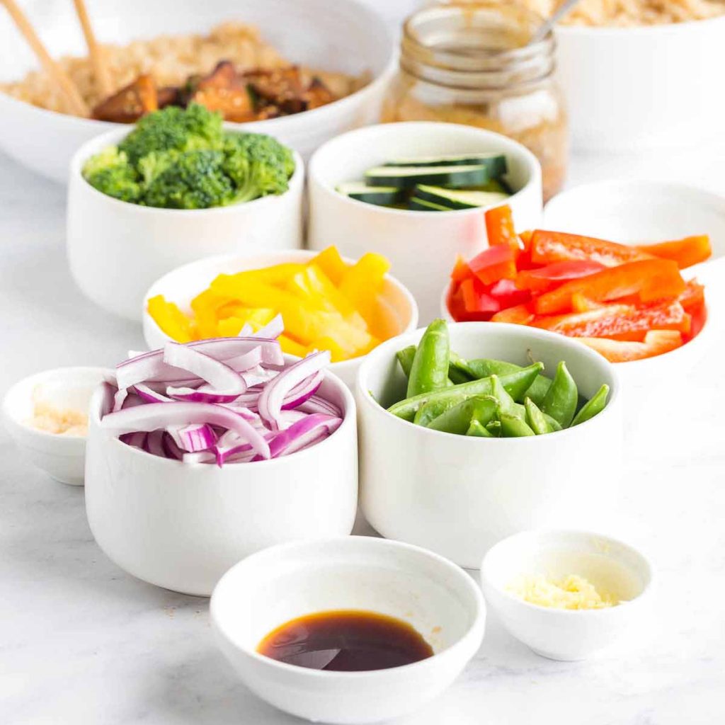 white bowls of prepped and cut veggies for teriyaki stir fry bowls