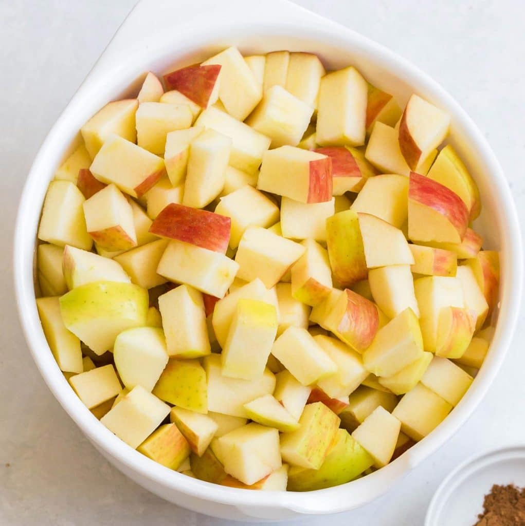 white bowl full of diced apples to make instant pot apple crumble.