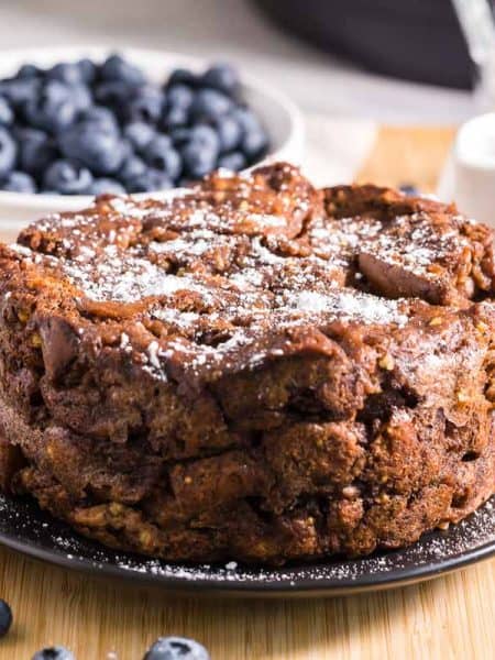 Healthy French Toast Casserole with powdered sugar on top and blueberries in the background
