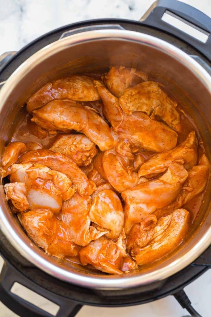 top down view of chicken and seasonings covered with hot sauce