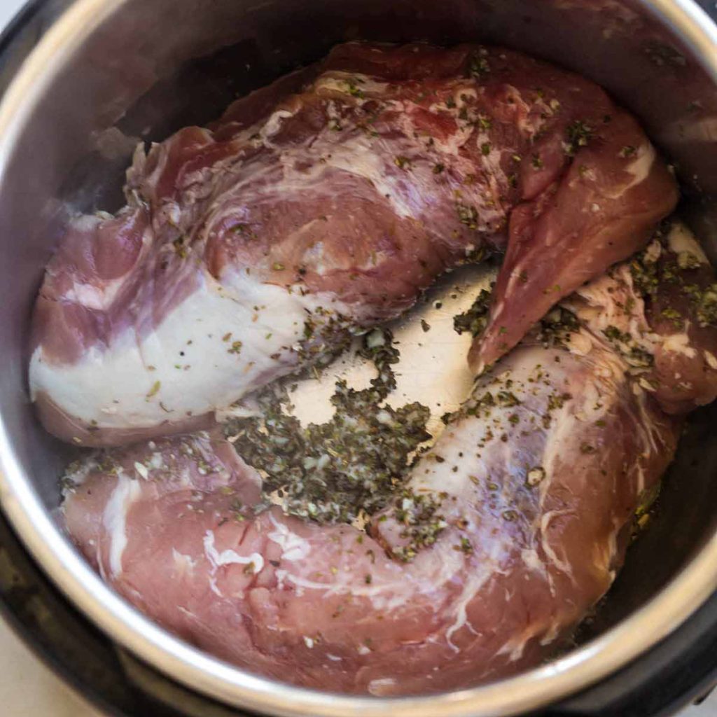 pieces of pork in an instant pot with seasoning
