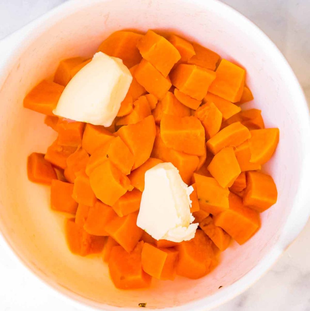 cooked, cubed sweet potato in a bowl with butter