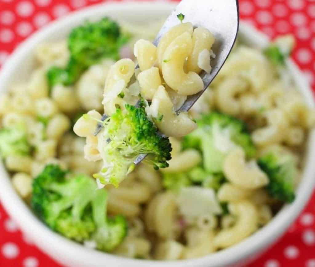 close up of broccoli and noodles on a fork