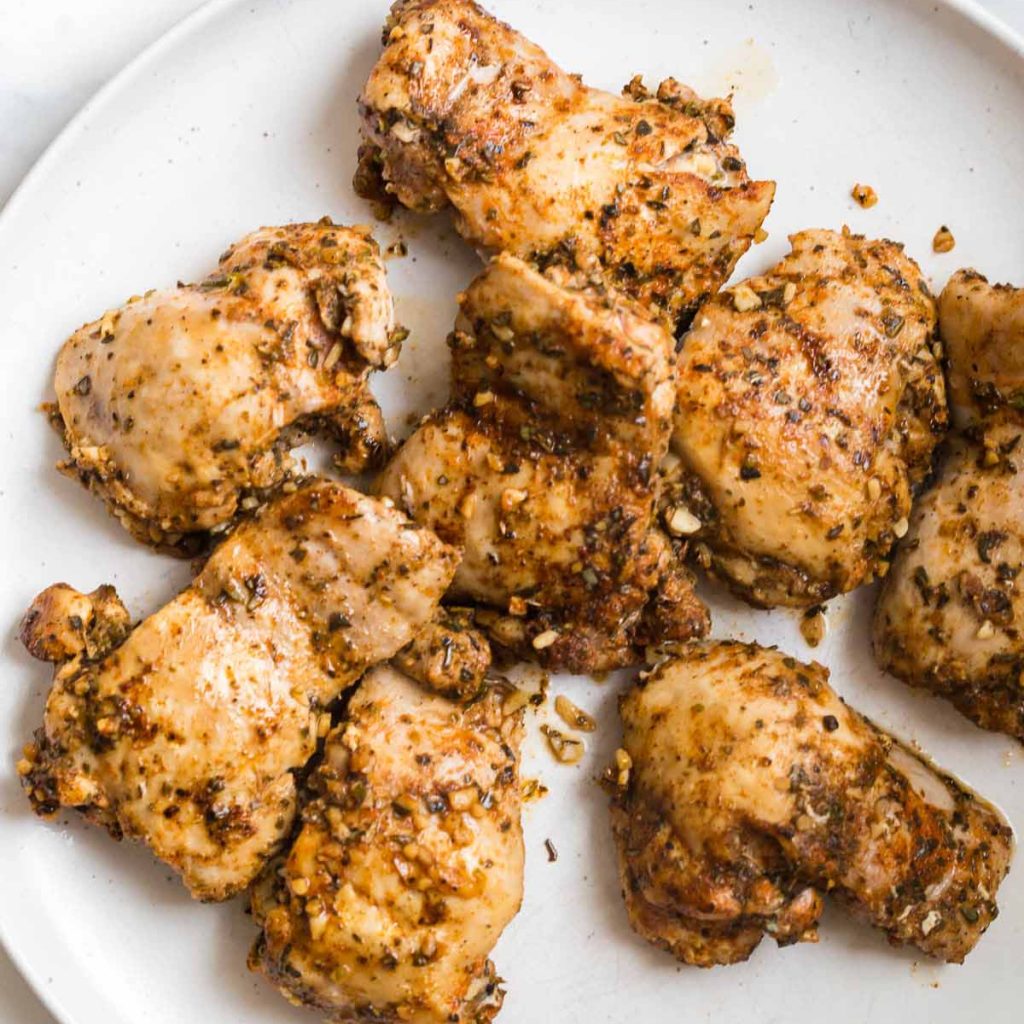 seasoned, seared chicken thighs on a white plate