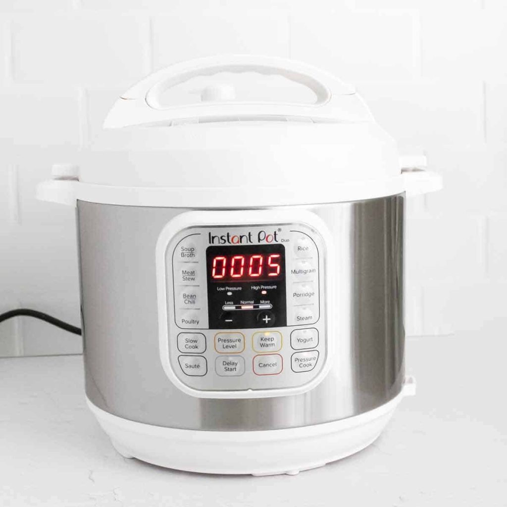white Instant Pot on a white counter showing 5 minutes for cook time