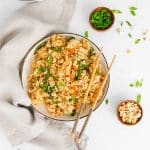 bowl of cooked fried rice with chopsticks resting on the side on the right side of the bowl