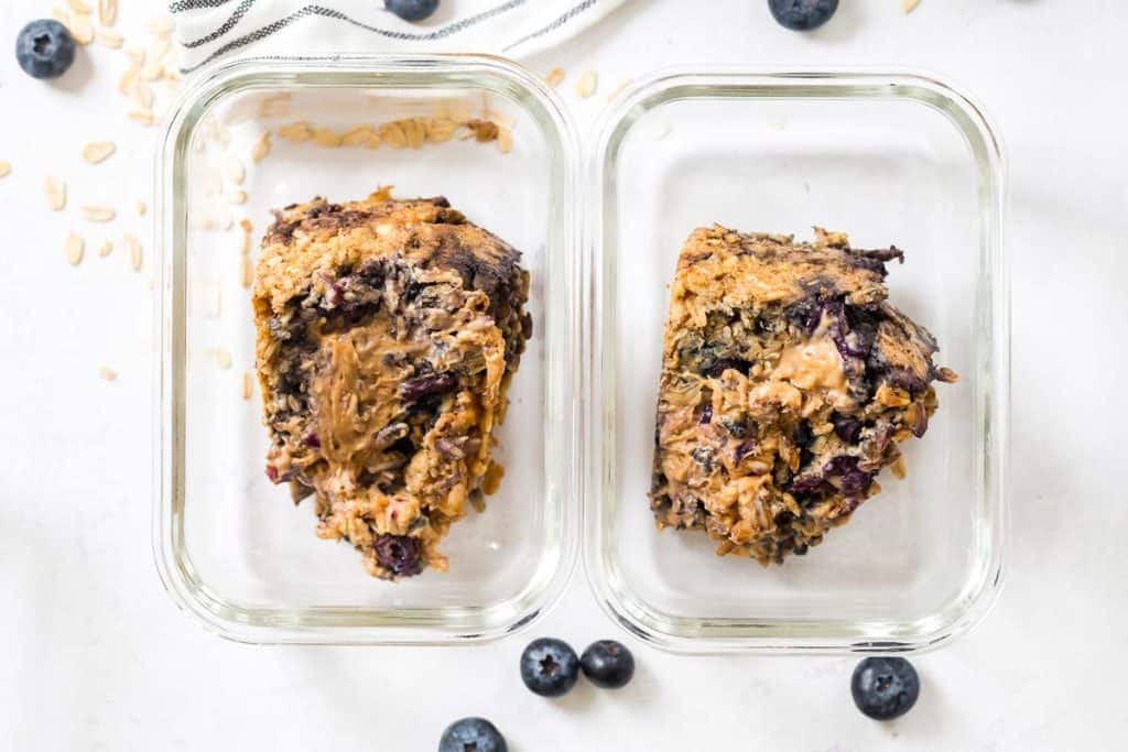 two glass meal prep containers with Blueberry Oatmeal Bake slices inside of them