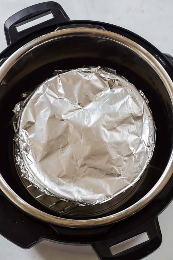 instant pot with a circular pan covered with foil inside