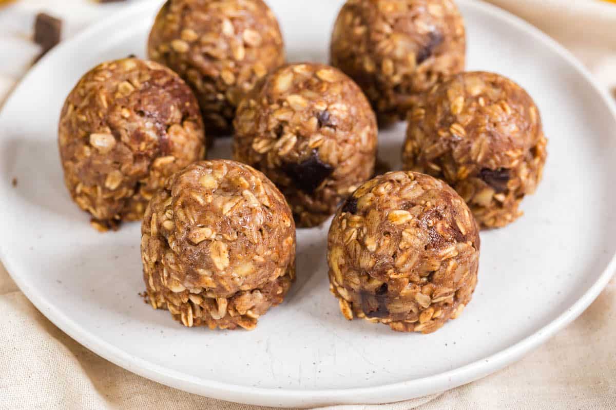 Seven banana oatmeal bites on a white plate.