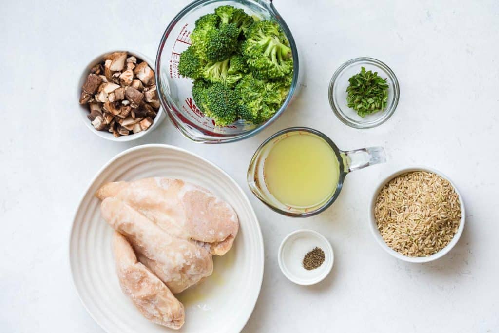 ingredients for One Pot Chicken and Rice with Veggies including: frozen chicken breasts, broccoli, mushrooms, chicken stock, uncooked rice, and spices