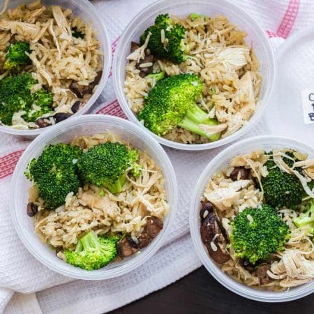 four containers with rice and chicken and broccoli shown from above