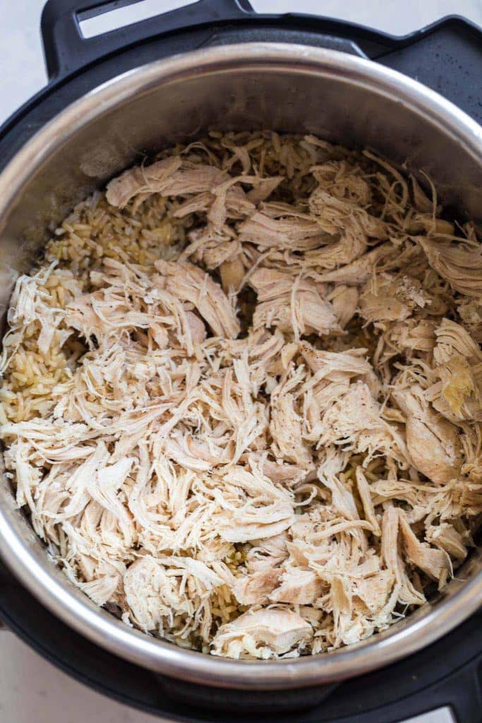 shredded chicken on top of cooked brown rice in Instant Pot