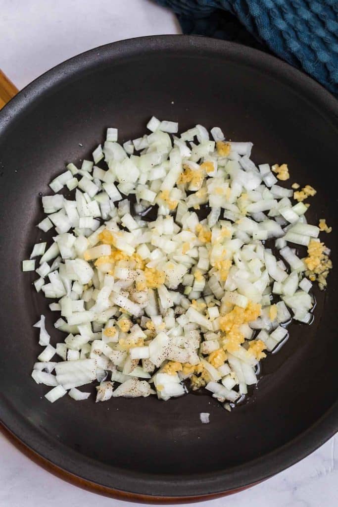 black pan with diced onions, garlic, and oil