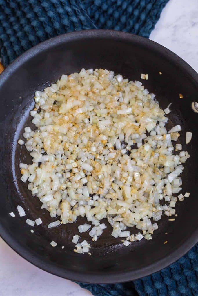 black pan with sautéed onions, garlic, and oil