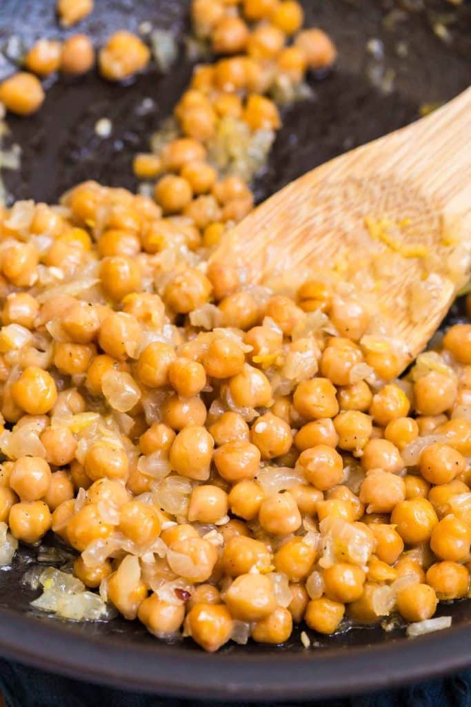 sautéed chickpeas with lemon and oil in a black pan