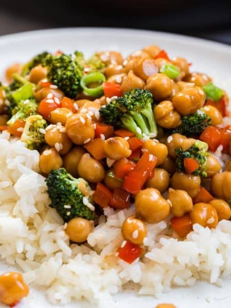 close up image of white plate with bed of white rice topped with a chickpea and broccoli mixture