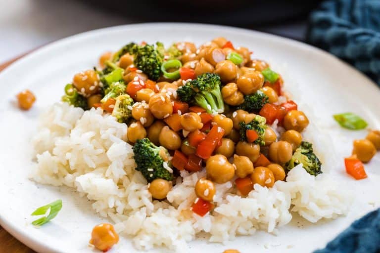 close up image of white plate with bed of white rice topped with a chickpea and broccoli mixture