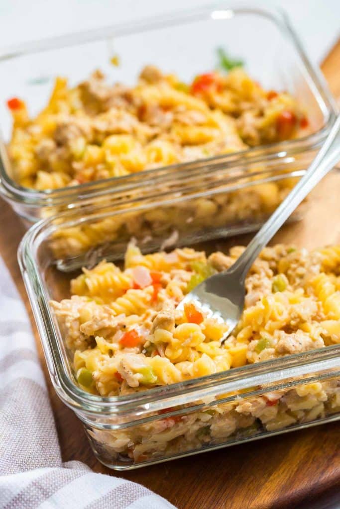 glass meal prep containers with pasta being picked up by fork
