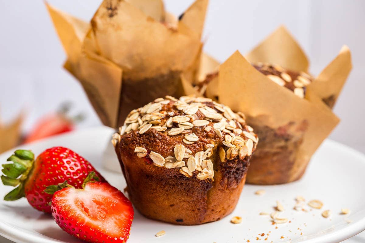 Strawberry Muffins on a white plate with cut strawberry